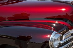 the front end of a classic car with its hood up and chrome paint on it