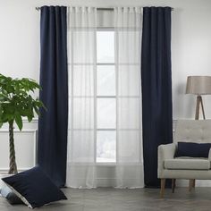 a living room filled with furniture and a window covered in blue drapes next to a potted plant