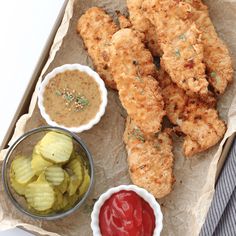 fried chicken sticks with pickles and ketchup on the side