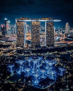 an aerial view of the marina bay area at night, with lights in the foreground