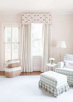 a living room filled with furniture and a window covered in white curtains next to a chair