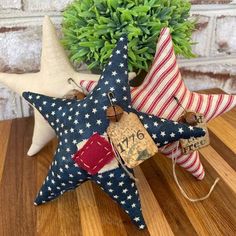 three patriotic stars are sitting on a wooden table next to a potted plant and tag