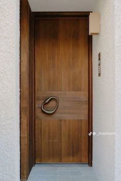 a wooden door with a metal handle on the front and side of it in a white wall