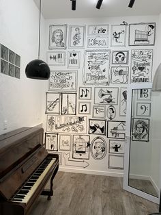 a piano in front of a wall with musical notes on it's side and an overhead light