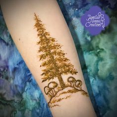 a gold glitter christmas tree tattoo on the arm