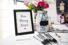 there is a mason jar with candy in it next to some cards and pens on the table