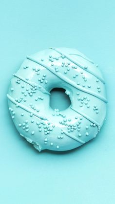 a donut with white frosting and sprinkles on it's side