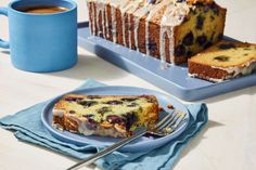 a blue plate topped with cake next to a cup of coffee