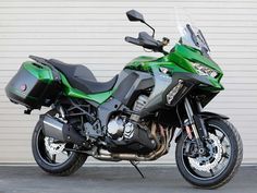 a green motorcycle parked in front of a garage door