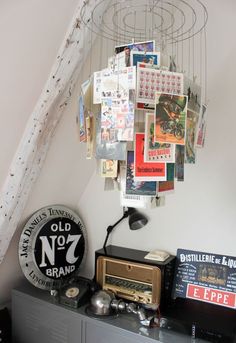 an old radio sits on top of a dresser in a room with posters hanging from the ceiling