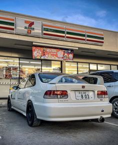 two white cars parked in front of a pizza hut