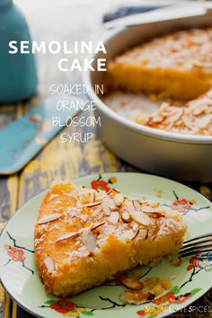 a piece of cake sitting on top of a green plate next to a pan filled with almonds