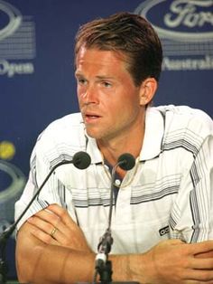 a man sitting in front of a microphone at a press conference