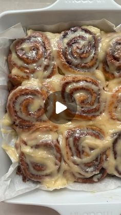 a pan filled with cinnamon rolls covered in icing