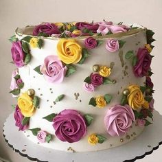 a white cake with yellow, pink and purple flowers on it