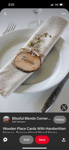 a white plate topped with a piece of wood next to a fork and knife on top of a table