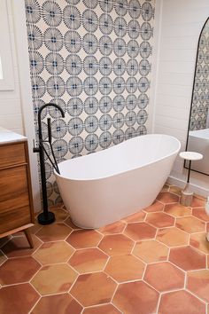 a white bath tub sitting on top of a bathroom floor