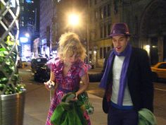 a man and woman walking down the street at night