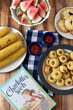 some watermelon and corn on the cob are next to other food items