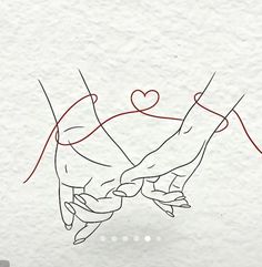 two hands holding each other with a heart drawn on the wall in the back ground