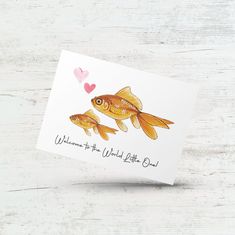 a card with two goldfishs on it and a heart in the background that says, welcome to the world little bird