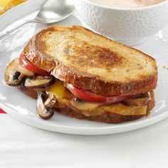 a grilled cheese and mushroom sandwich on a plate next to a cup of coffee