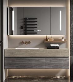 a bathroom with a sink, mirror and lights on the wall above it's counter