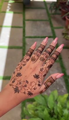 a woman's hand with henna tattoos on it