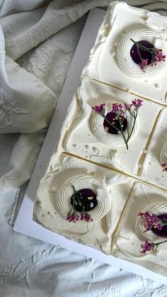 four square pieces of cake sitting on top of a white sheet covered in icing