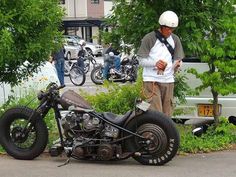 a man standing next to a parked motorcycle