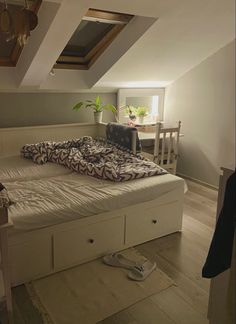 a bed sitting in the middle of a room next to a table