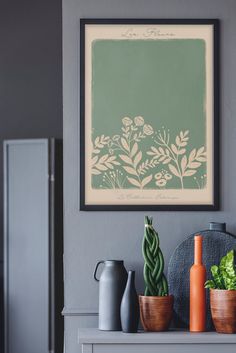 a painting on the wall above a table with vases and plants