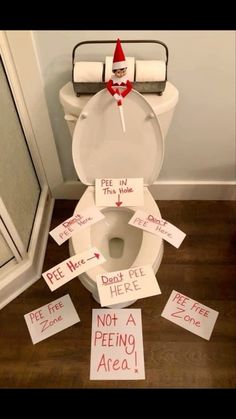 a toilet that has been decorated with signs on the lid and in front of it