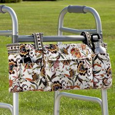 two purses hanging on a metal rack in the grass