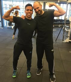 two men posing for the camera in a gym