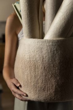 a woman is holding two large rolls of toilet paper in her hands and she has one arm wrapped around the rolled up toilet paper