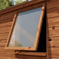 a wooden window on the side of a building with a skylight above it and trees in the background