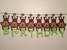 a birthday banner with monkeys hanging from it's sides