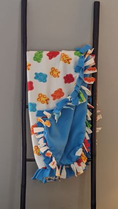 a baby blanket is hanging on a ladder