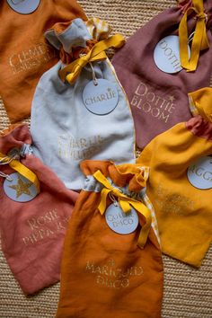 five baby bibs with name tags on them sitting on the floor next to each other