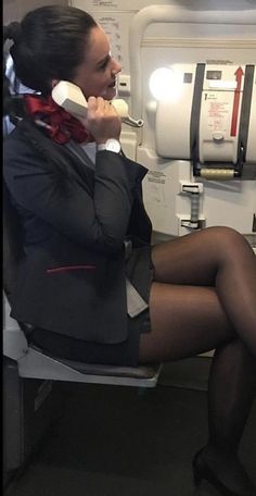 a woman sitting on an airplane talking on the phone