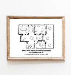 a white wall with a wooden frame hanging on it and a black and white floor plan