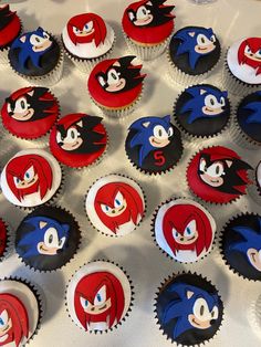 cupcakes with red and blue frosting are arranged on a white tablecloth