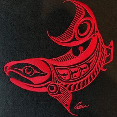 an intricately designed red fish on black paper