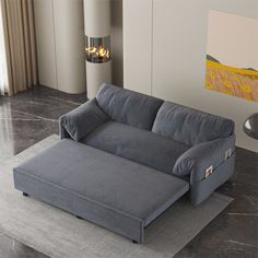 a grey couch sitting on top of a gray rug