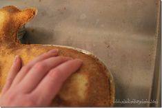 a person touching the bottom of a pan with food on it