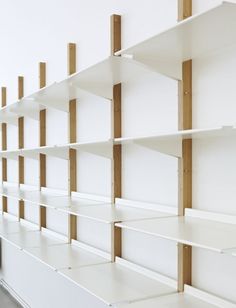 white shelves lined up against the wall with wooden posts sticking out of each one's sides