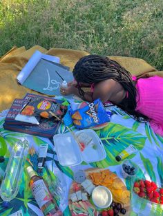 a woman laying on top of a blanket covered in food