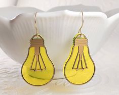 For all your brightest ideas!  These light bulb earrings are styled after vintage incandescent bulbs.  They are made with florescent yellow acrylic, which gives them a delightful subtle glow when they catch the light. These are designed with handmade gold filled hooks, but if you prefer I can swap them for  sterling hooks (please note that the bulb design will still have gold accents).  They are a smidge over 2.25" long! Last picture shows the post and chain version with dainty bulbs - also avai Shrinky Dink, Handmade Gold, Cnc Machine, Incandescent Bulbs, Gold Accents, Clay Earrings, Jewelry Earrings Dangle, Light Bulb, Gold Filled