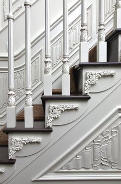 a staircase with white railing and brown carpet